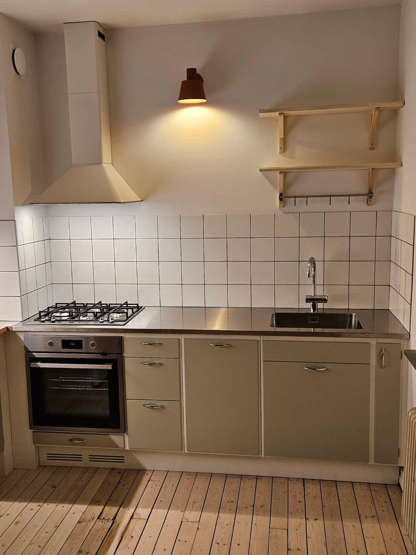 Retrokök med gröna luckor, gashäll och vitt kakel